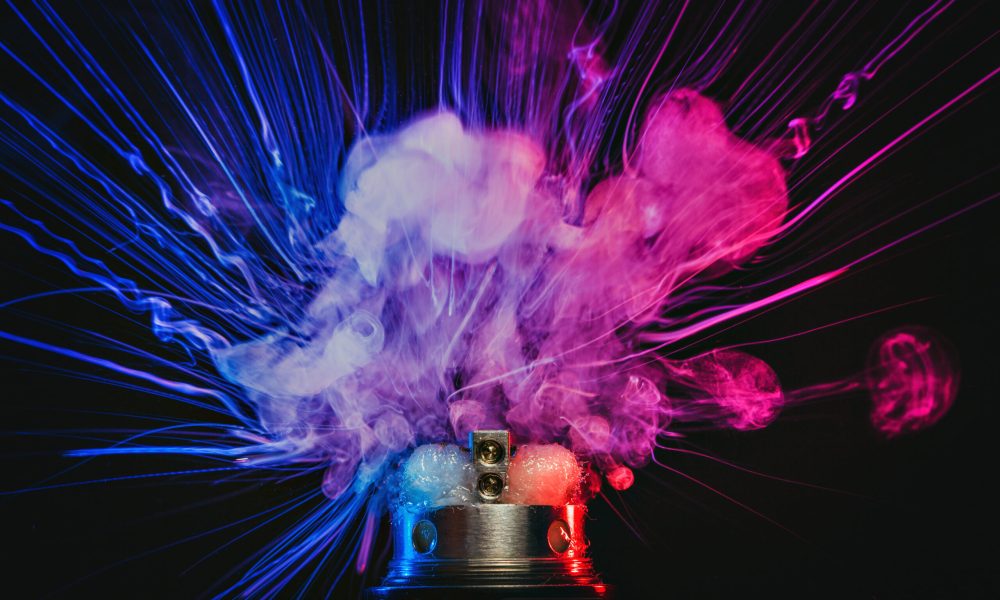 Electronic Cigarette vape explosion. Dark background.